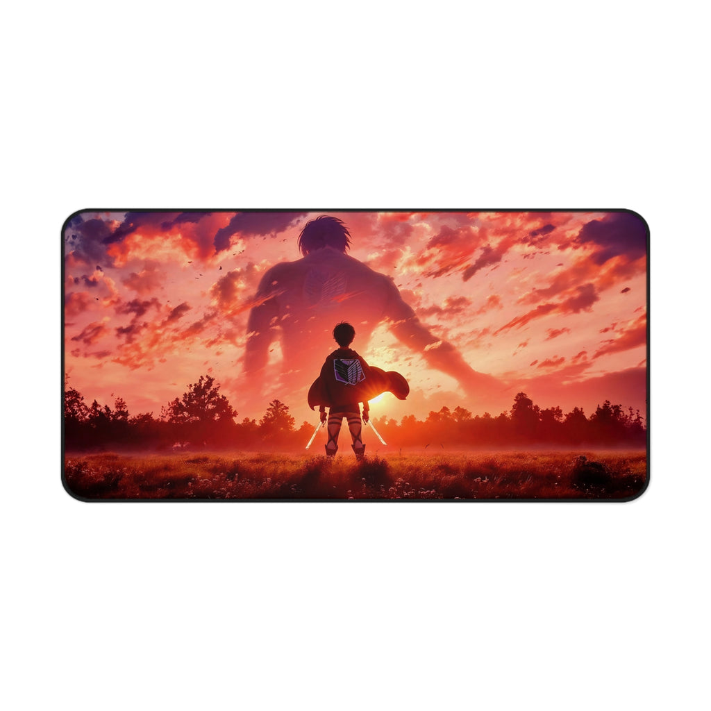 A rectangular desk mat with rounded corners featuring an Attack on Titan anime-style illustration of Eren Yeager standing in a field with ODM swords, facing a giant silhouette of the Attack Titan against a dramatic orange and pink sunset sky.
